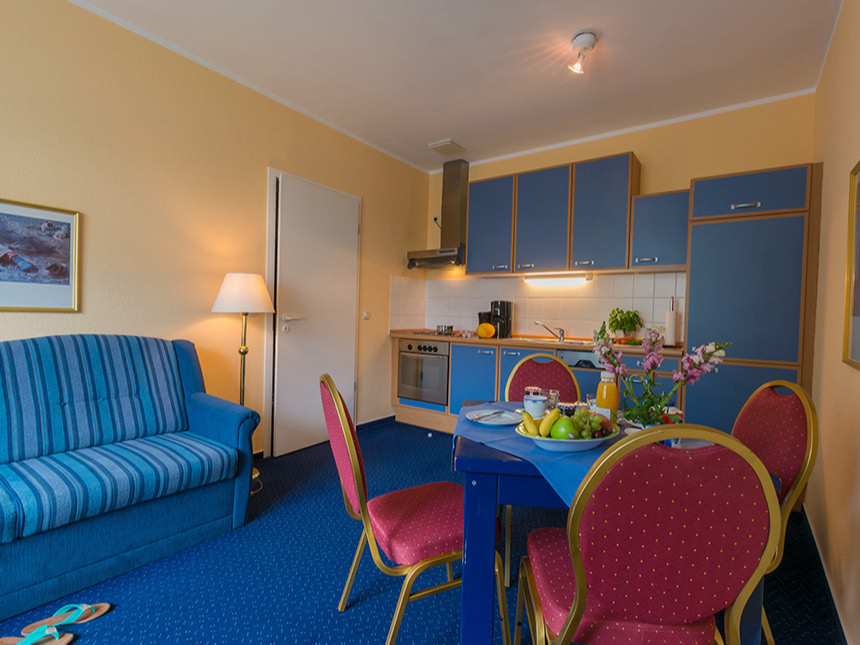 Wohnbereich mit Küchenzeile, Couch und Tischgruppe