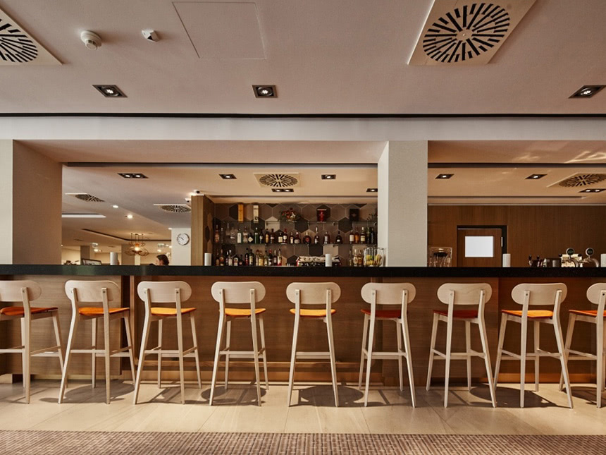 mehrere Barhocker an der Hotelbar