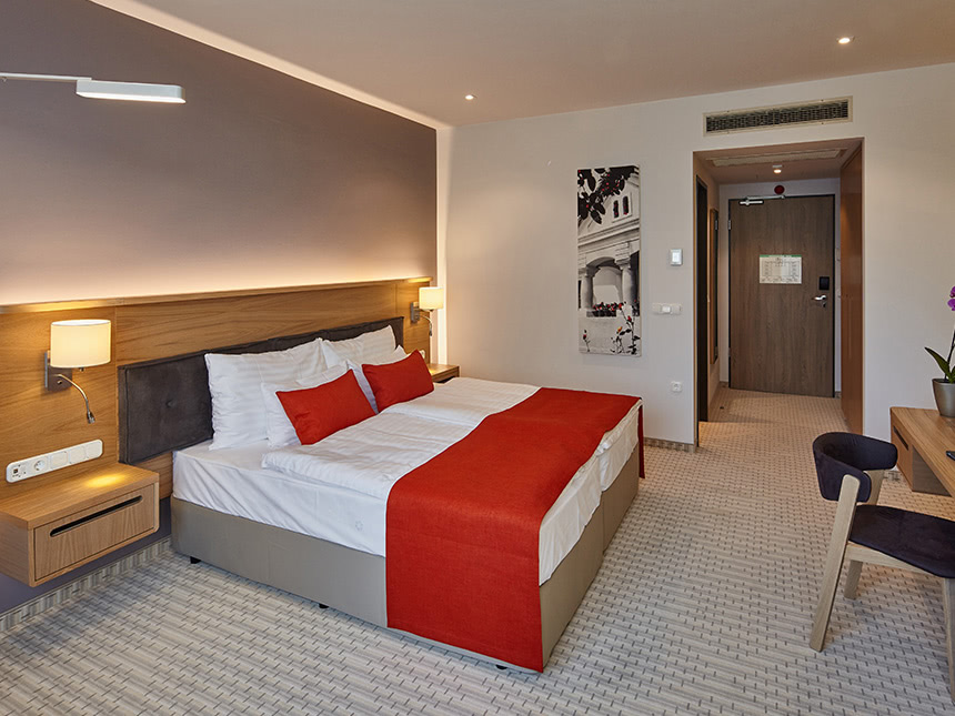 modernes Doppelzimmer mit Boxspringbett, Schreibtisch und Stuhl