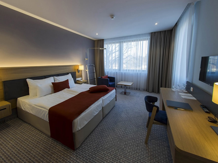 geräumiges Doppelzimmer mit Boxspringbett, Schreibtisch und TV