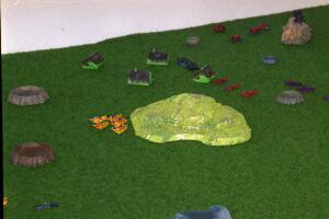 Somene tries a bit of flanking. The hill in the picture is the very first one I ever made. I didn't think of painting a base color first, and it shows...