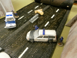 The cops are still stuck at the roadblock.