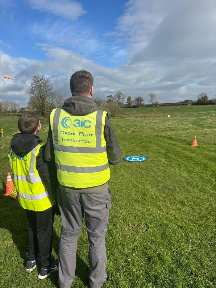Robert Dobbin 3iC Drone Pilot Instructor with a 11 year Student learning to fly a drone at Drone Pilot Training Academy in April 2026