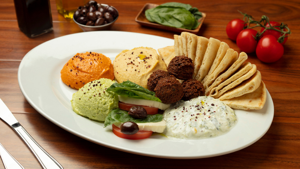 Appetizer Combination: Feeds up to 4 and includes homemade garbanzo, beet, and edamame hummus, caprese, tzatziki, and falafels.