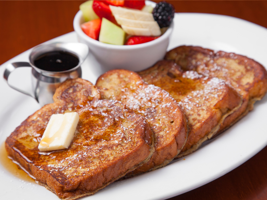 Traditional French Toast (Cinnamon, Orange Zest, and Powdered Sugar. Syrup and side of Fresh Strawberries and Bananas).