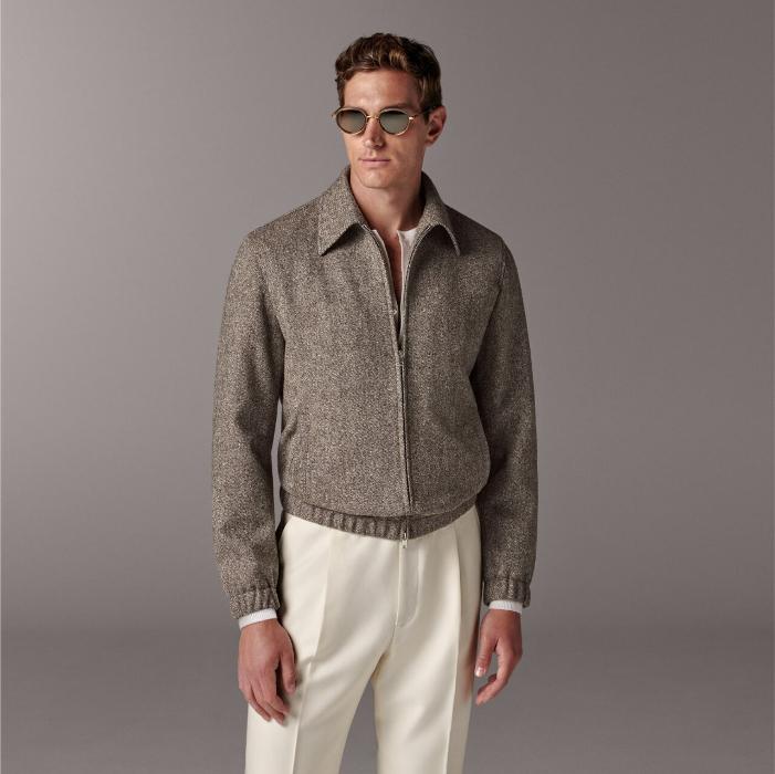 Brown bomber jacket featuring a straight collar, double-ended zip closure, and welted pockets. Designed with an elastic hem and cuffs for comfort, and includes practical inside pockets. Hip-length and fully lined.