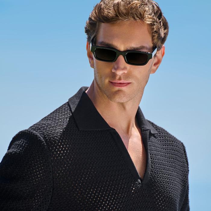 This black buttonless polo sweater is tailored to a regular fit and features a crochet texture, a classic collar, and short sleeves.