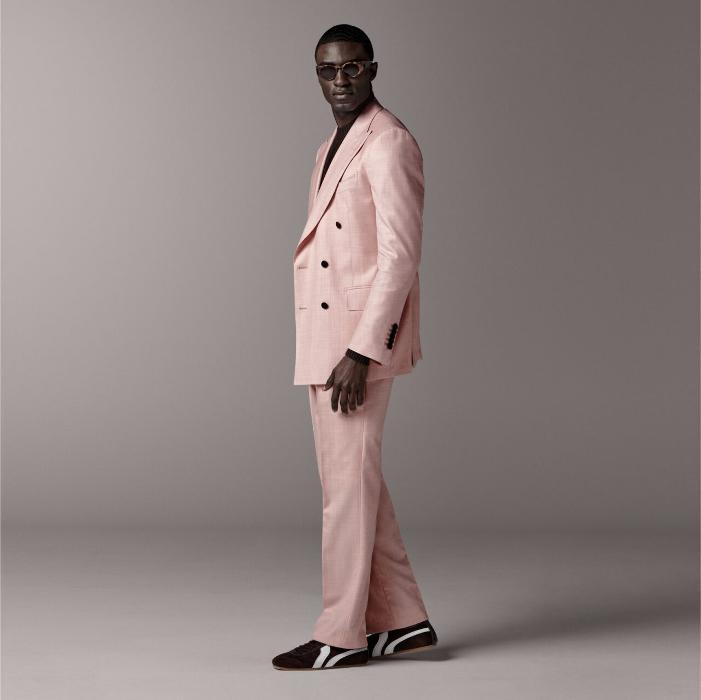 This pink suit is cut to a tailored fit with a slim chest and padded shoulders, featuring a double-breasted closure and peak lapel. Paired with wide-leg trousers, high-rise, single pleat, and belt loops.