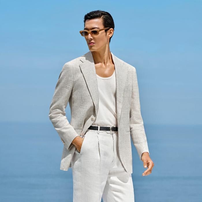 This light grey checked blazer is cut to a relaxed fit, offering a roomy chest and natural shoulders. It features a wide notch lapel, jetted pockets, and a single-breasted closure.