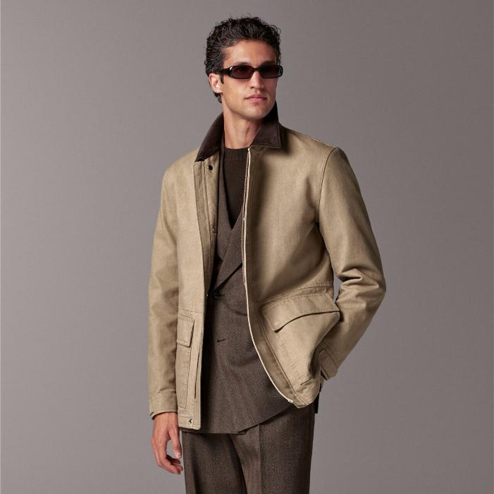 A versatile sand work jacket with a contrasting collar, featuring hidden snap buttons, a zip closure, and an interior waist drawstring. Complete with flapped patch and slanted pockets for functionality.