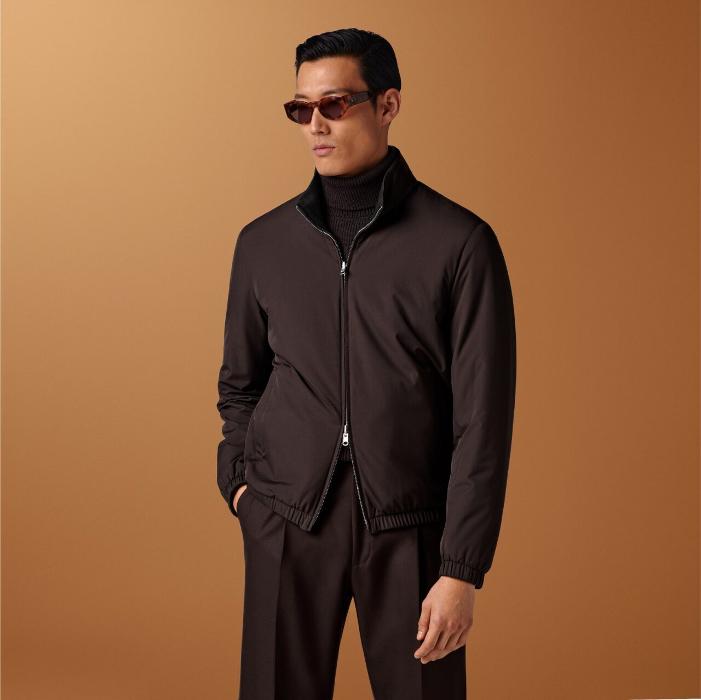 Dark brown bomber jacket, reversible with a high collar. Features a hip-length cut, double-ended zip, elastic hem and cuffs, welted pockets, and inside pockets. Perfect for versatile style.