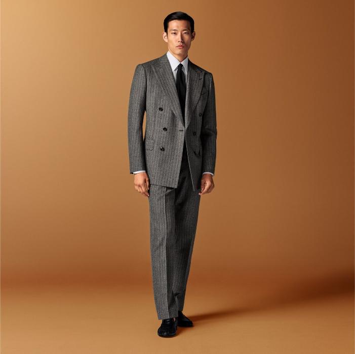 This dark brown striped suit features a tailored fit with a padded shoulder and double-breasted closure. Paired with straight-leg, mid-rise trousers featuring a flat front and belt loops
