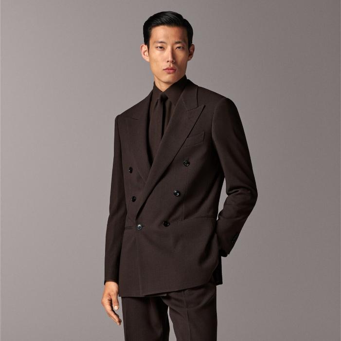 This dark brown suit is cut to a relaxed fit with a structured shoulder and paired with wide-leg straight trousers featuring a single pleat and belt loops for added comfort.