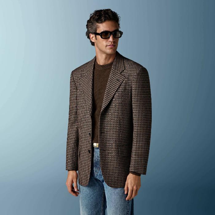 This mid brown checked blazer is cut to a relaxed fit — roomy through the chest and waist with a soft, natural shoulder — and features a notch lapel, patch pockets, and half-canvas construction.