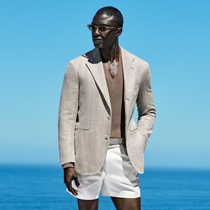 This taupe herringbone blazer is cut to a relaxed fit, offering a roomier chest and shoulder for a laid-back silhouette. It features a natural shoulder, wide notch lapel, and jetted pockets.