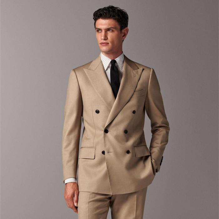 This sand suit is cut to a tailored fit with a padded shoulder and double-breasted closure for a sleek look. Paired with straight-leg trousers featuring a flat front and belt loops for a refined finish.
