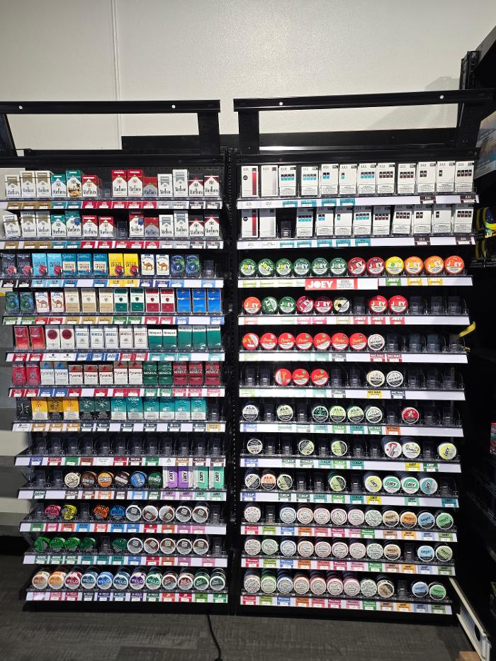 Cigarette and nicotine pouches display featuring JUUL and Alp Nicotine Pouches
