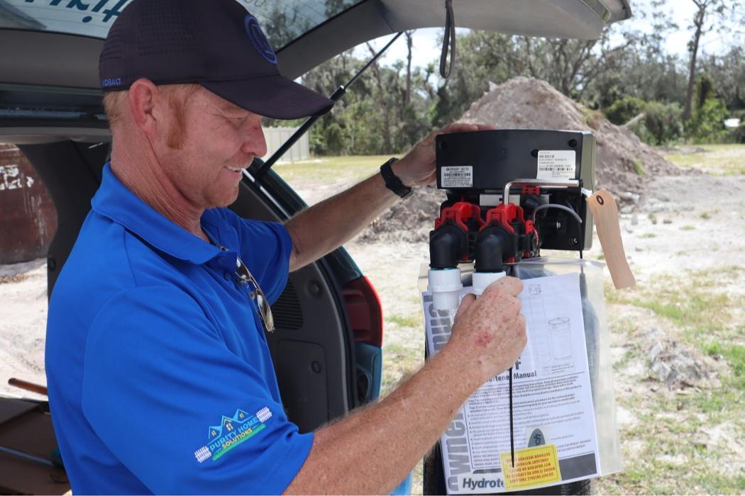 Technician Happilly installaling an Advanced Conditioning Water Filtration System.