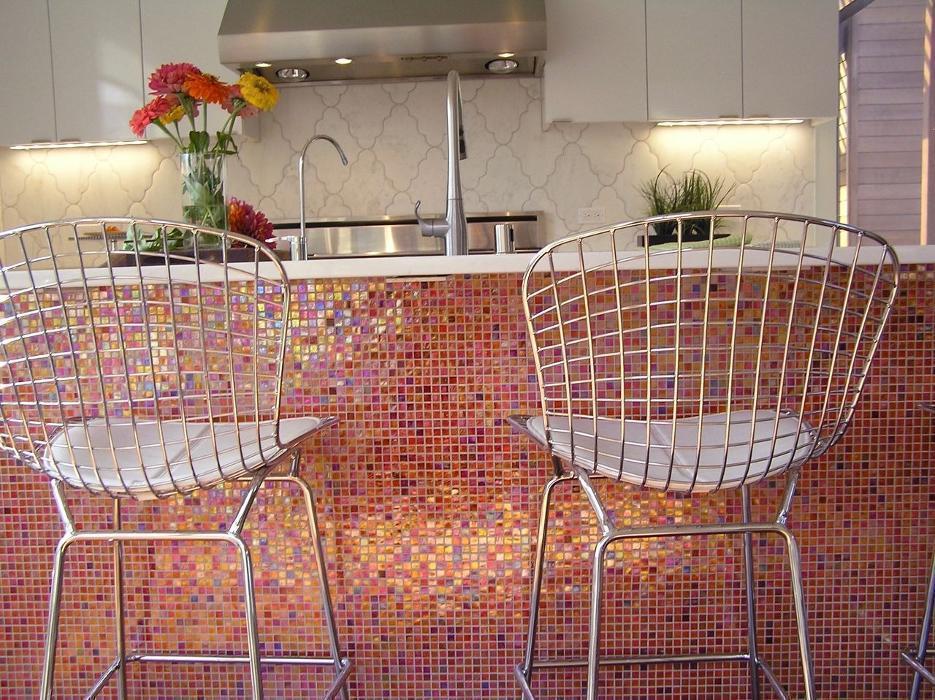 The kitchen features a striking orange range and an island wrapped in dazzling polychromatic Italian glass tile, paired with a marble arabesque backsplash.