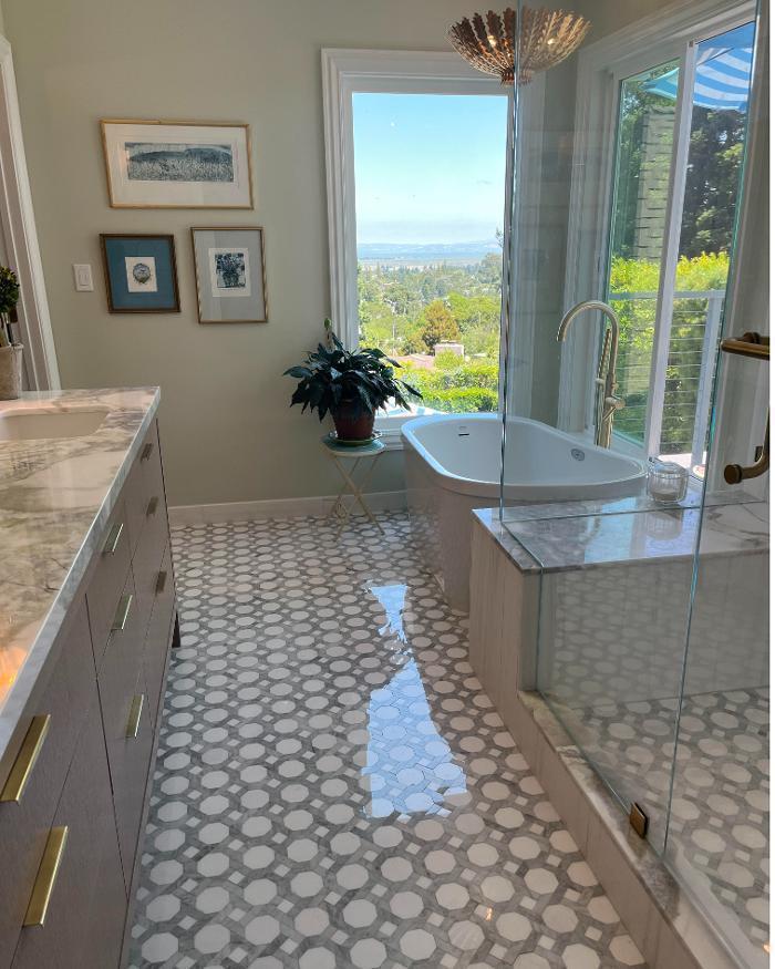 This refined bathroom design features octagonal mosaic flooring, Dolomite marble shower walls, and a graceful freestanding tub. Decorative lighting enhances the space, uniting function and artistry in a modern bathroom remodel.