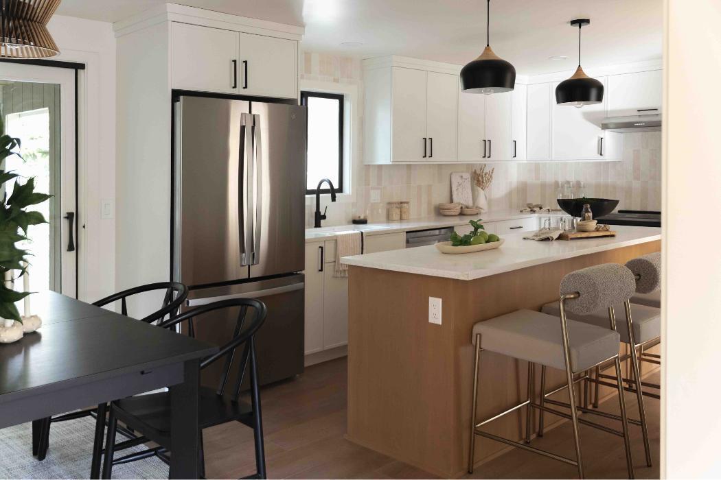 Kitchen with alder island and white shaker perimeter cabinets. White zelige backsplash.