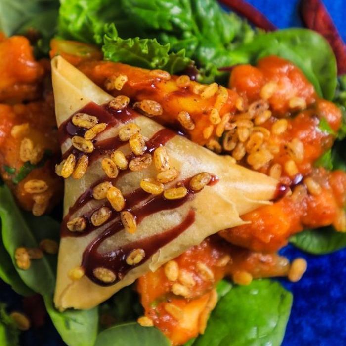 Crispy samosa chaat at Prana Indian Restaurant, Cambridge, topped with chickpeas, chutneys and spices for the perfect Indian street food experience in our award winning Mill Road restaurant.