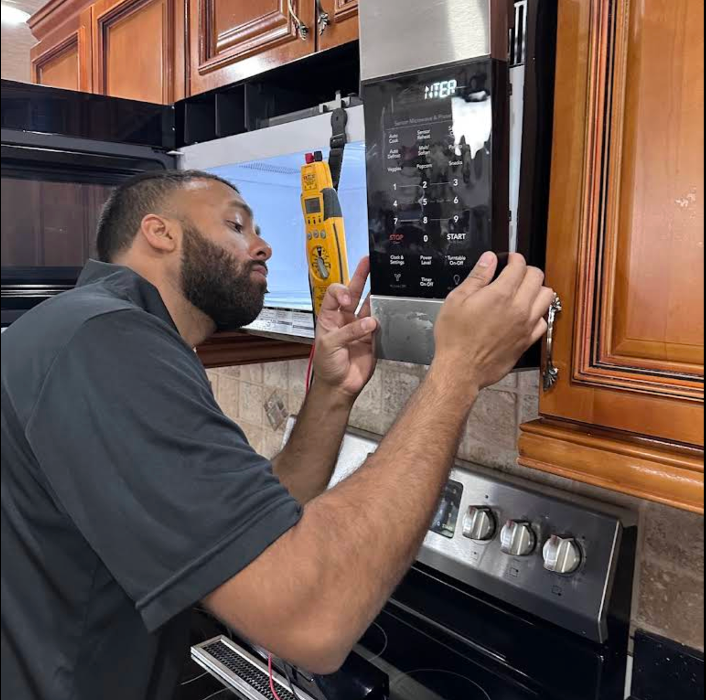 Amyan Appliance Service LLC technician performing a microwave repair in Seminole, FL. Our licensed experts handle appliance diagnostics and repairs with precision, keeping your home running smoothly.
