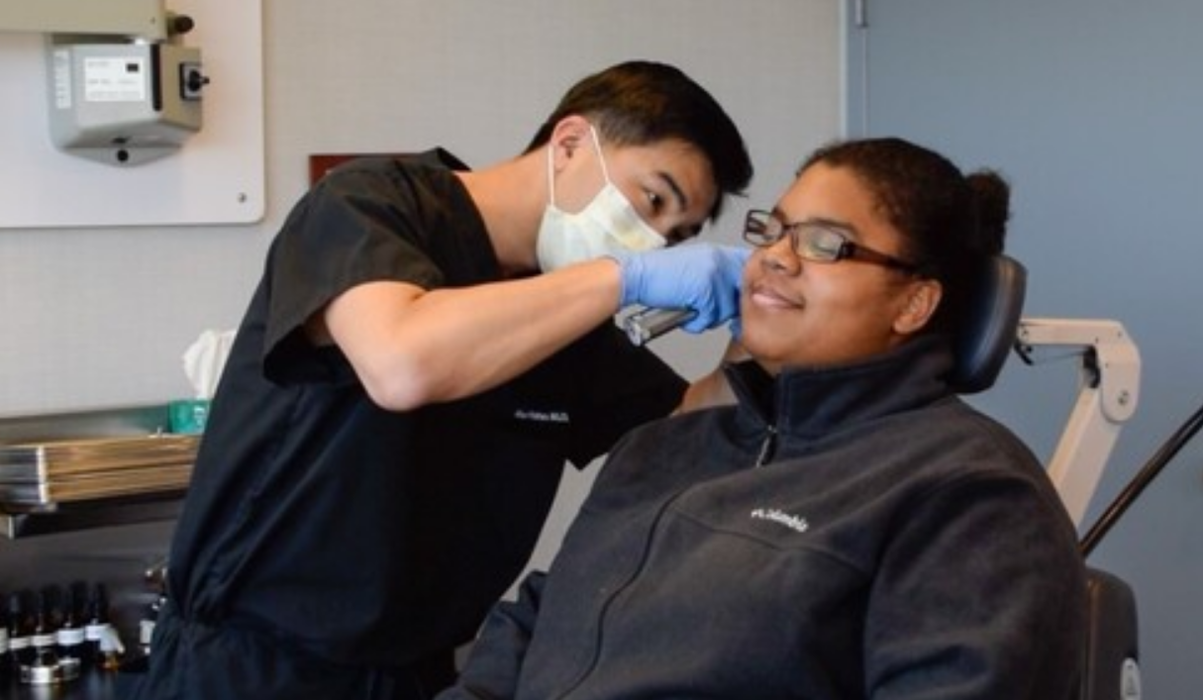 Samuel Hahn, MD, checking patient's ear