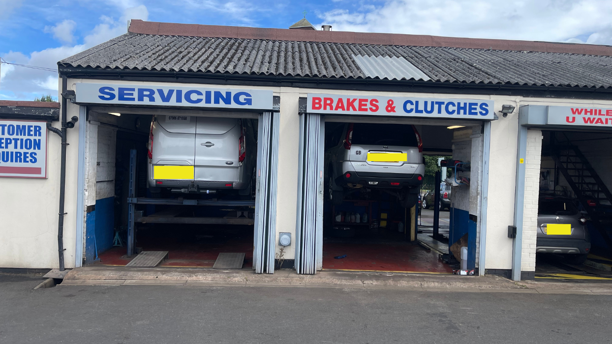 All ramps busy with van in for repairs, car also under repairs and MOT Test taking place in the last bay.