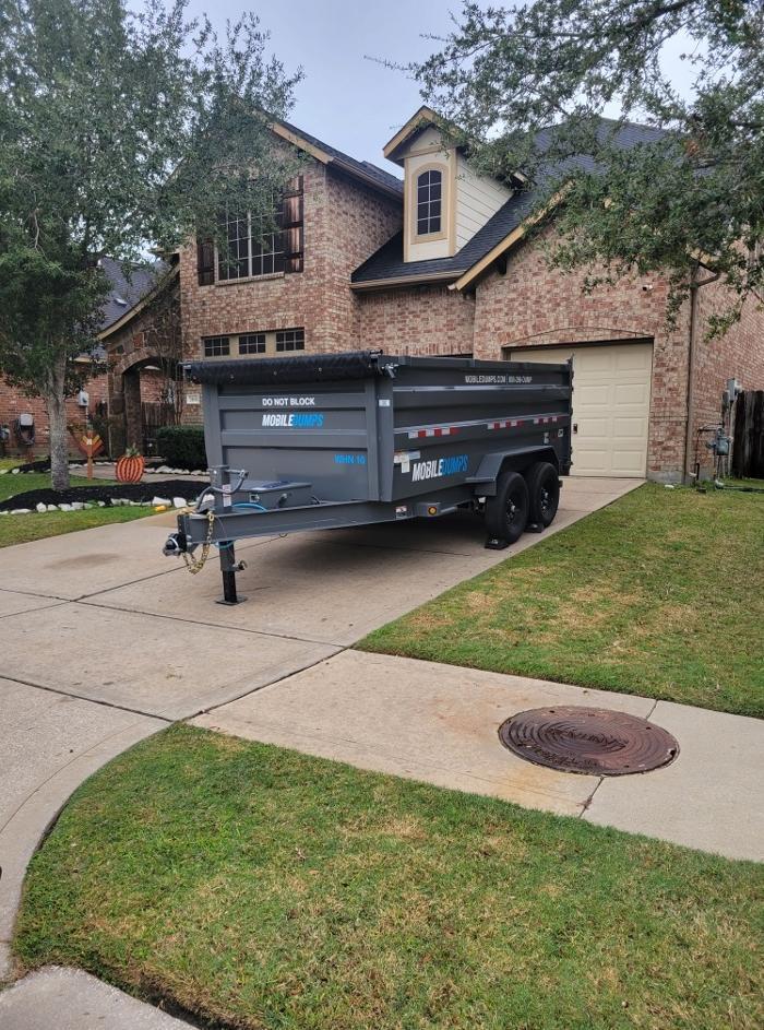 Driveway-safe Mobiledumps Houston 14-yard dumpster placed at a residential property. Perfect for home cleanouts, renovations, moving prep, and junk removal projects.
