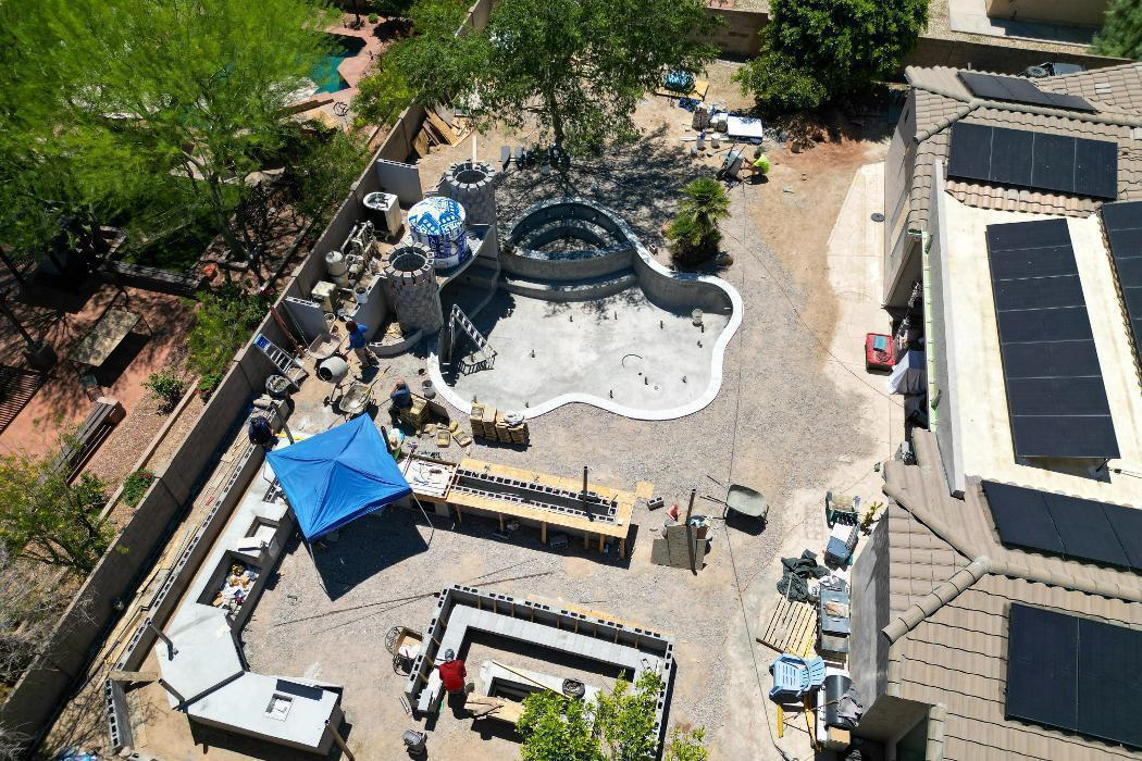 Drone view of a full backyard project including pool, BBQ area, hardscape, and structures. AE Outdoor Living handling complete outdoor living builds.