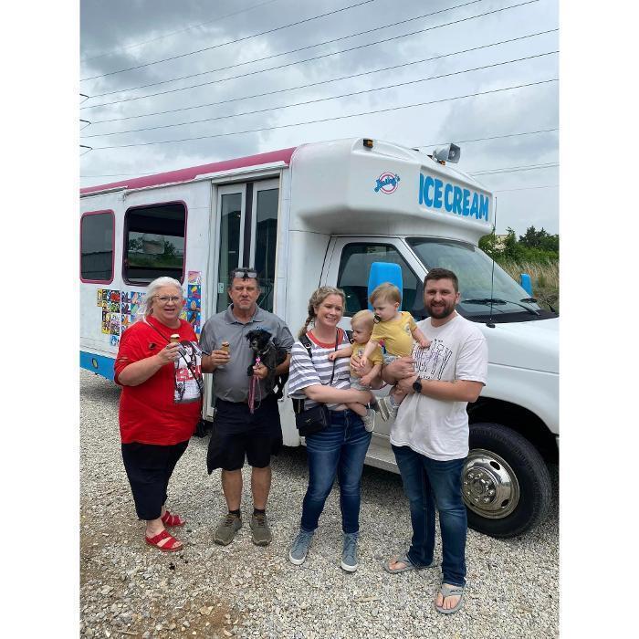 Group of people posing with dogs in front of the Your Dog’s Best Days mobile van.