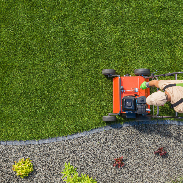 Lawn mowing being carried out with a professional petrol mower, showing clean edging and an even finish. Highlights the convenience of petrol-powered equipment, meaning no need for customer electricity or extension leads.
