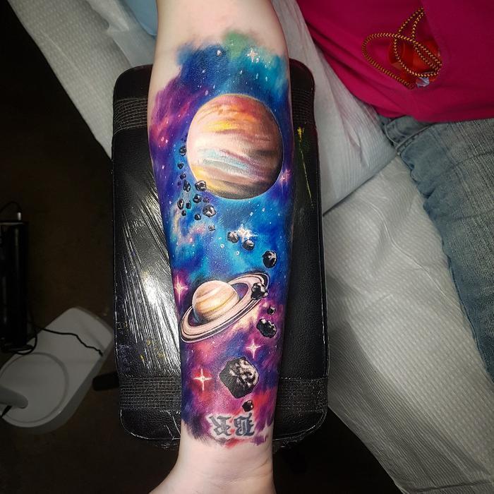 Color realism space tattoo by Cory. Planets, asteroids, and galaxy nebula with vivid blues, purples, and oranges.