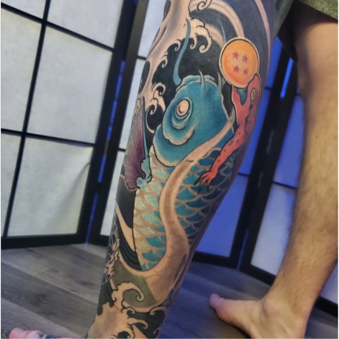 Japanese-inspired leg sleeve with koi fish, waves, and frog. Vibrant color work blending traditional Japanese style with pop culture elements.