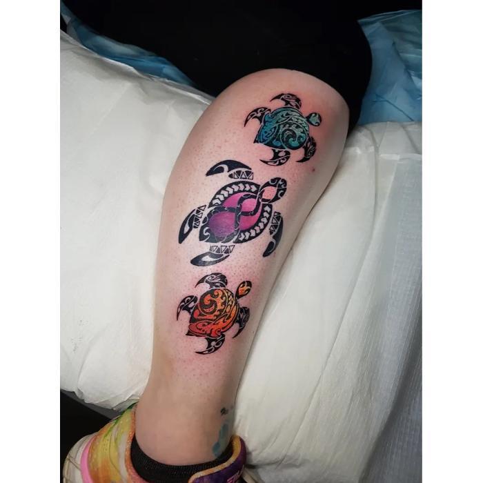 Colorful Polynesian turtle tattoos on calf. Walk-in piece combining tribal patterns with vibrant color work.