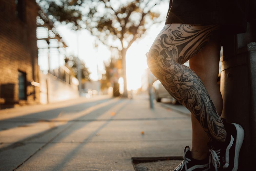 Japanese-inspired leg sleeve tattoo featuring chrysanthemum flowers and waves. Black and gray work by Red Arbor Tattoo.