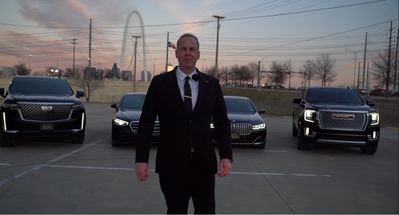 Executive chauffeur standing with luxury fleet providing premium black car and airport transportation services across Dallas and Fort Worth in the DFW area.
