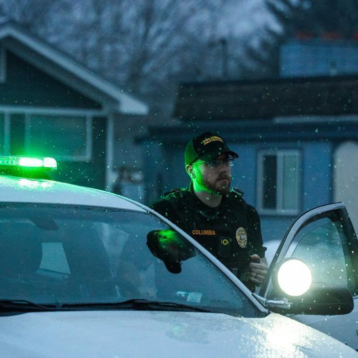 A security officer checks on a local business on an overcast day
