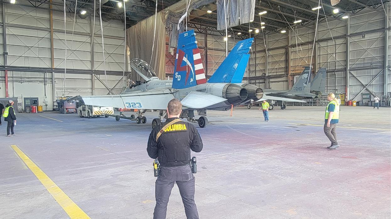 A Columbia Protection officer protects a NASA fighter jet containing classified material at Spokane International Airport