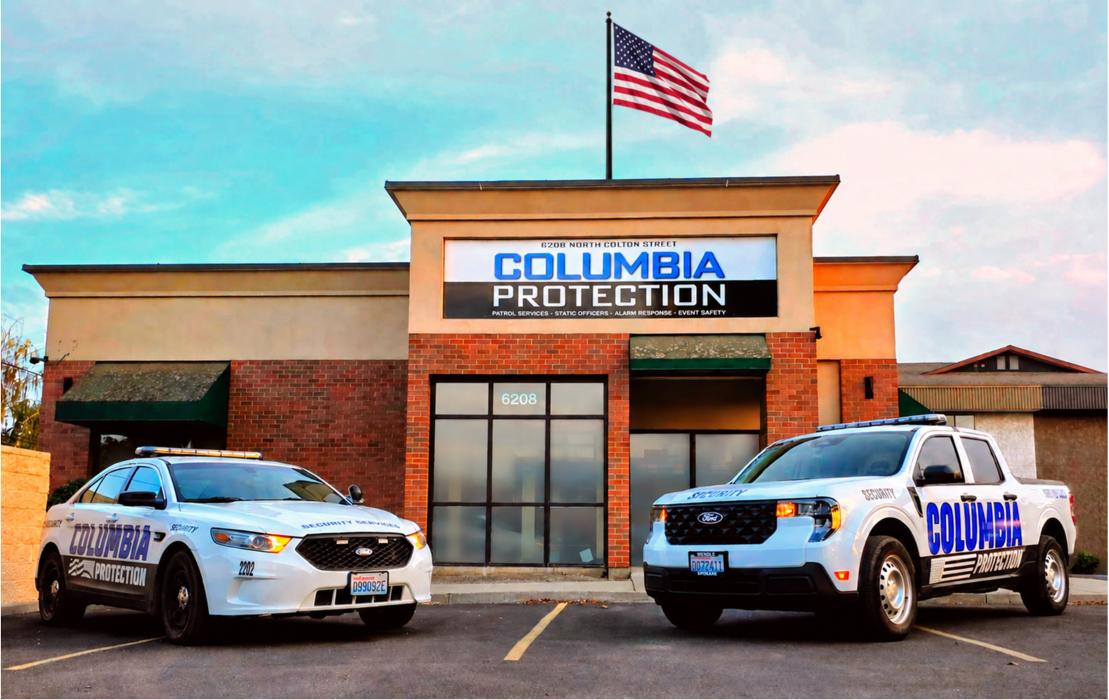 Two marked Columbia Protection patrol vehicles sit in front of the headquarters building in North Spokane