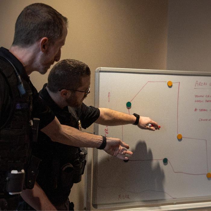 Security guards looking at an event layout whiteboard to plan the Cheney Rodeo