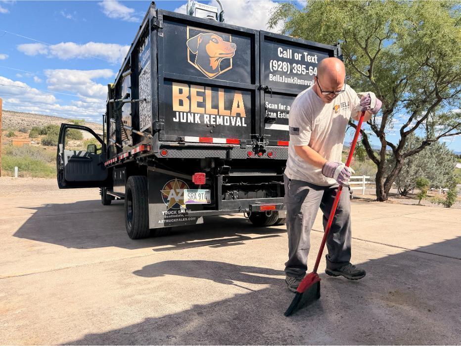 Bella Junk Removal crew member sweeping up the job site after a junk removal job.
