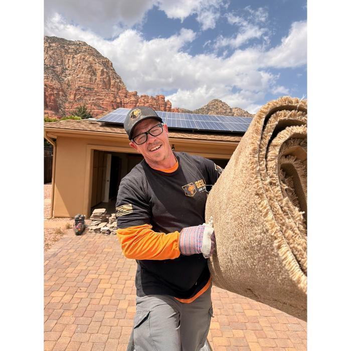 Robert hauling carpet into the dump truck.