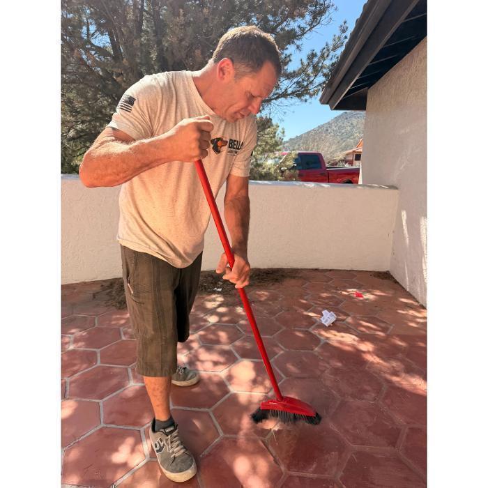 Joe sweeping the patio clean after a junk removal job. We leave every site better than we found it.