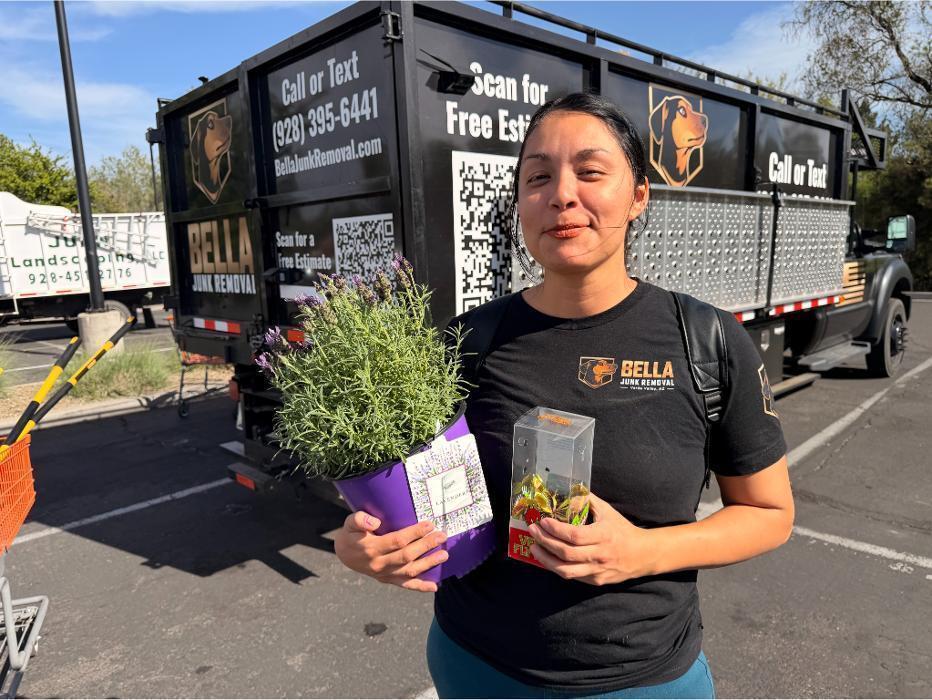 Bella Junk Removal co-leader Victoria holding house plants at Home Depot after a supply run for the truck.