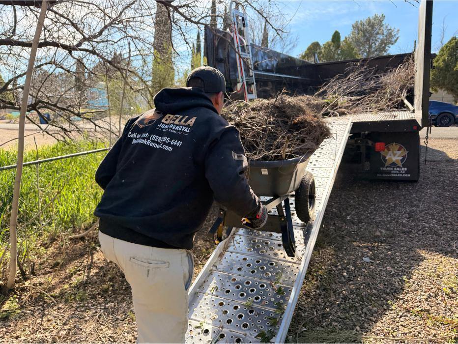 Joe hauling debris up the ramp of the F-550 in a wheelbarrow for dumping into the truck bed.
