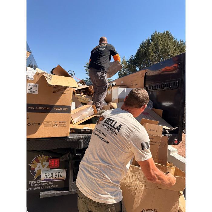 Joe tossing boxes into the F-550 while Robert stacks and compresses the load to maximize space.