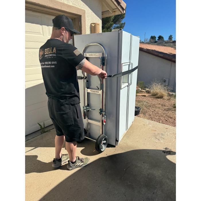 Nate loading a refrigerator onto a hand truck for removal.