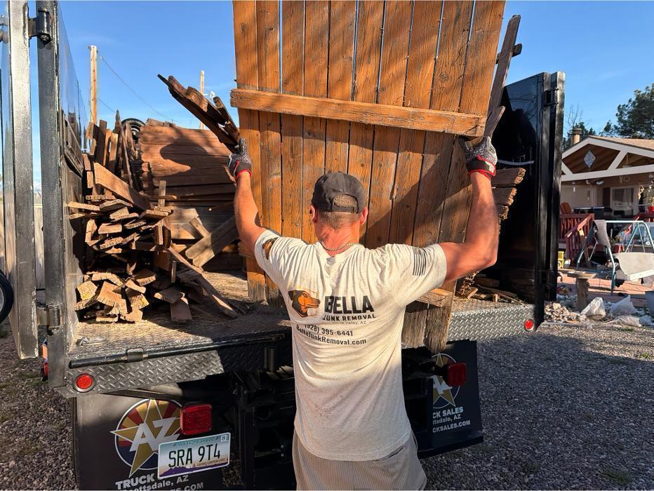 Joe loading demolished fence material into the F-550 for hauling.